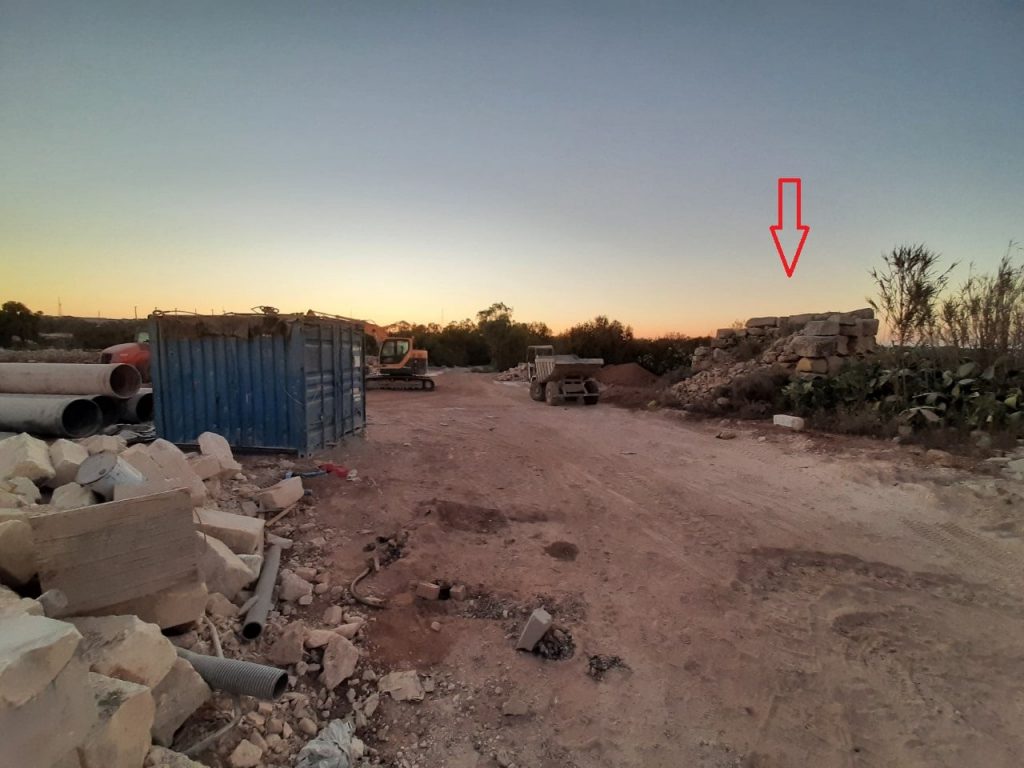 Photograph shows field adjacent to Tal-Wilġa ancient building levelled; it is used for storage, park heavy machinery and to deposit rubbish (Tal-Wilġa ancient building marked with an arrow).