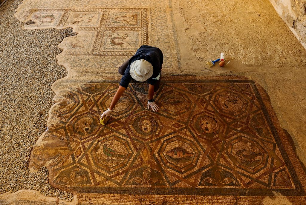 A restorer works on mosaics in the ancient city of Metropolis. Photo: AA