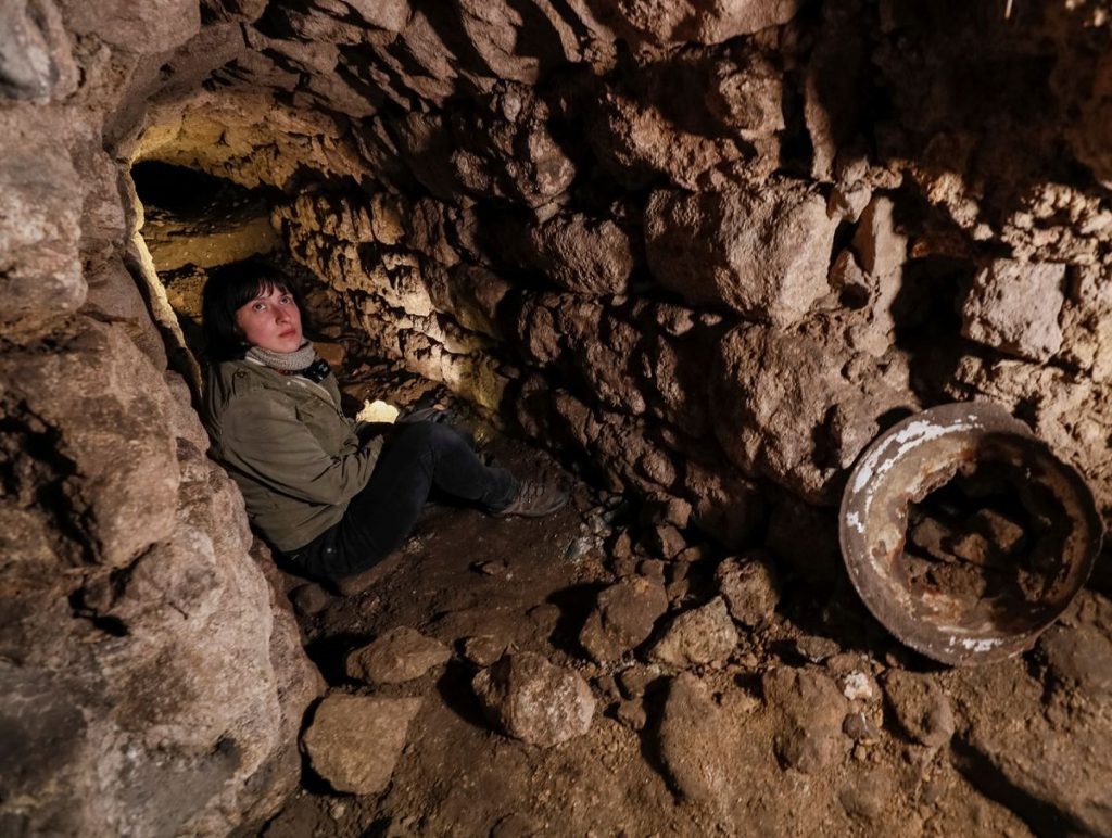 Historian Hanna Tychka explores a cave at the city sewage system where dozens of Jews were hiding from the Nazis during World War Two in Lviv, Ukraine. REUTERS/Gleb Garanich