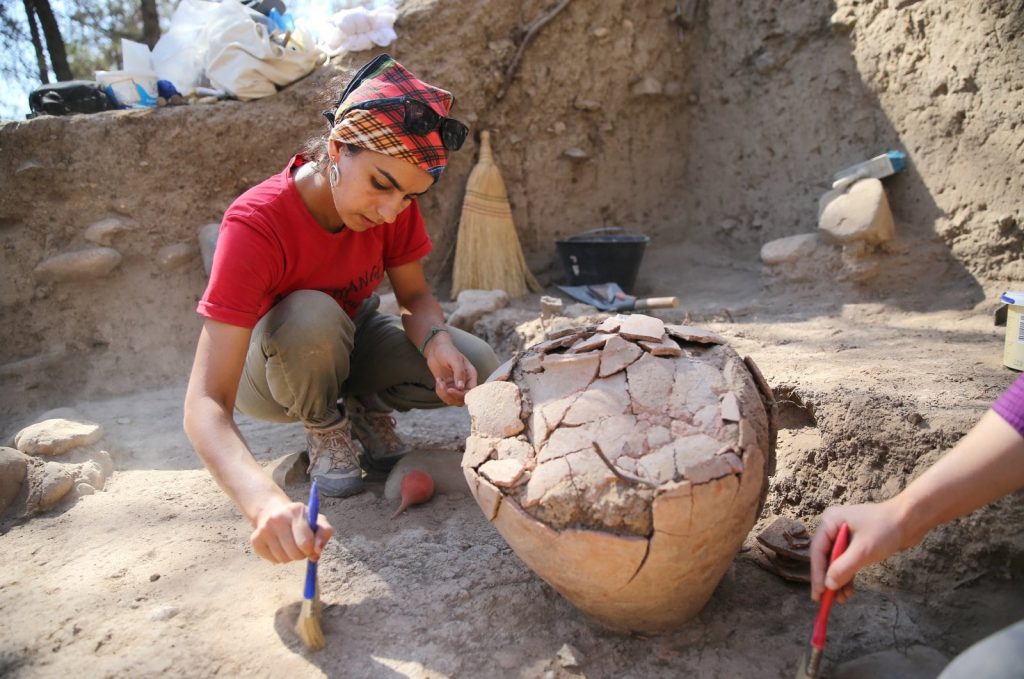 Archaeologists work on the 4,500-year-old jar in the Yumuktepe Mound, Mersin, southern Turkey. (AA Photo)
