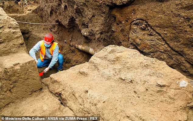 Adjacent to the tombs, the team's excavations also uncovered the remains of a young man who appeared to have been buried in the bare earth. Pictured: an archaeologist carefully excavates the some 2,000-year-old tombs in the Appio Latino quarter of Rome