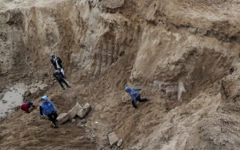 Palestinian boys play in an ancient cemetery reportedly dating back to the Roman era which was unearthed during construction work in Gaza City on January 31, 2022. (Mahmud HAMS / AFP)