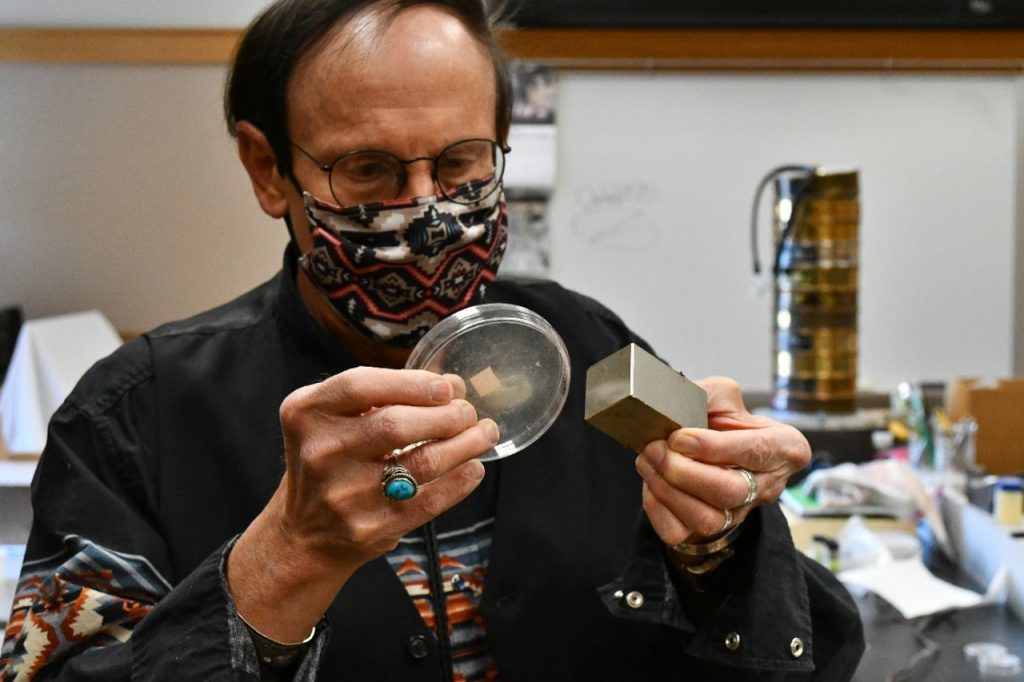 University of Cincinnati anthropology professor Kenneth Tankersley uses a magnet to show how micrometeorites collected at 11 Hopewell sites contain metals such as iron. UC's analysis found they also contain high levels of platinum and iridium. Photo/Michael Miller
