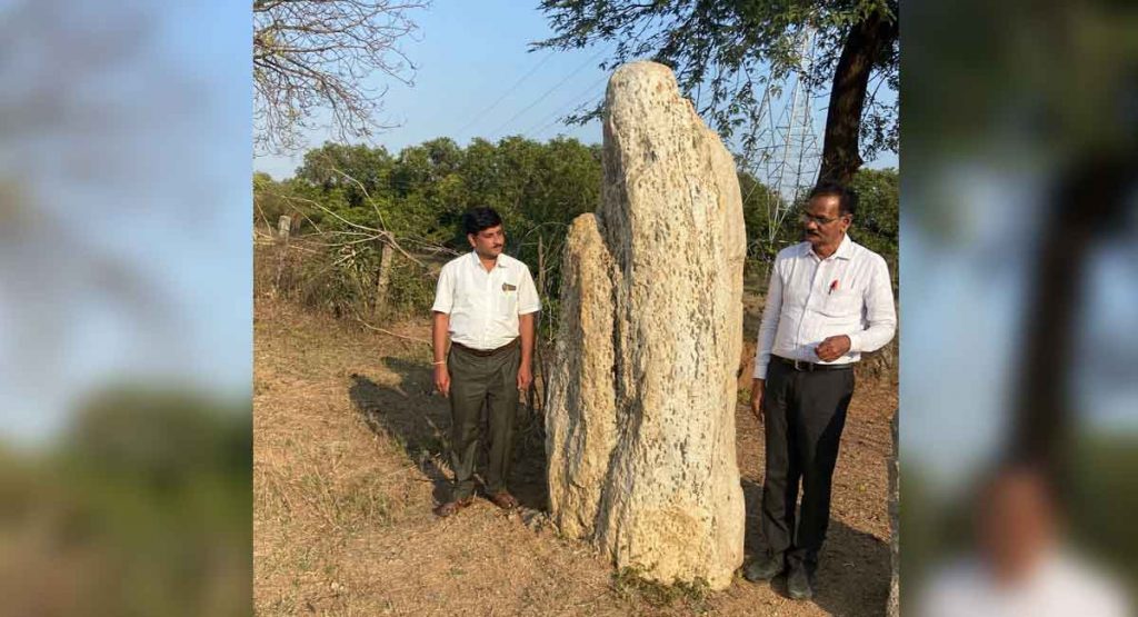 Archaeologist Dr Sivanagi Reddy (right) and D.R. Shyamsundar Rao, designs in-charge, Buddhavanam project, who was accompanying the former, stand beside the menhir found in Mahbubabad district. — DC Image