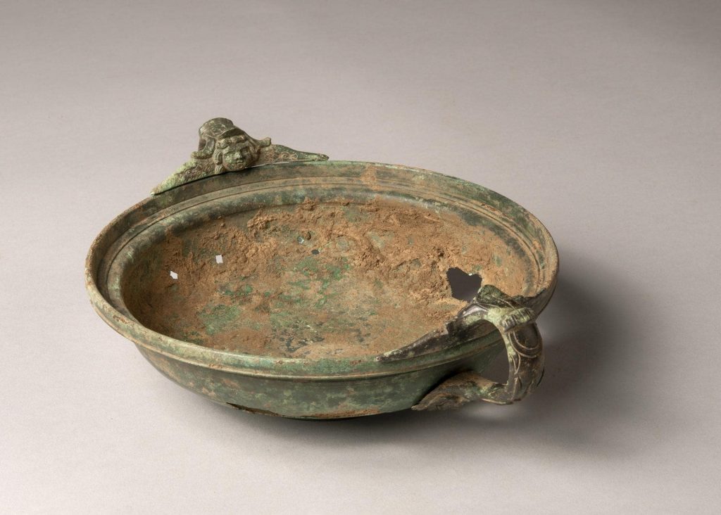 Bottom view of the bronze bowl with its two handles.