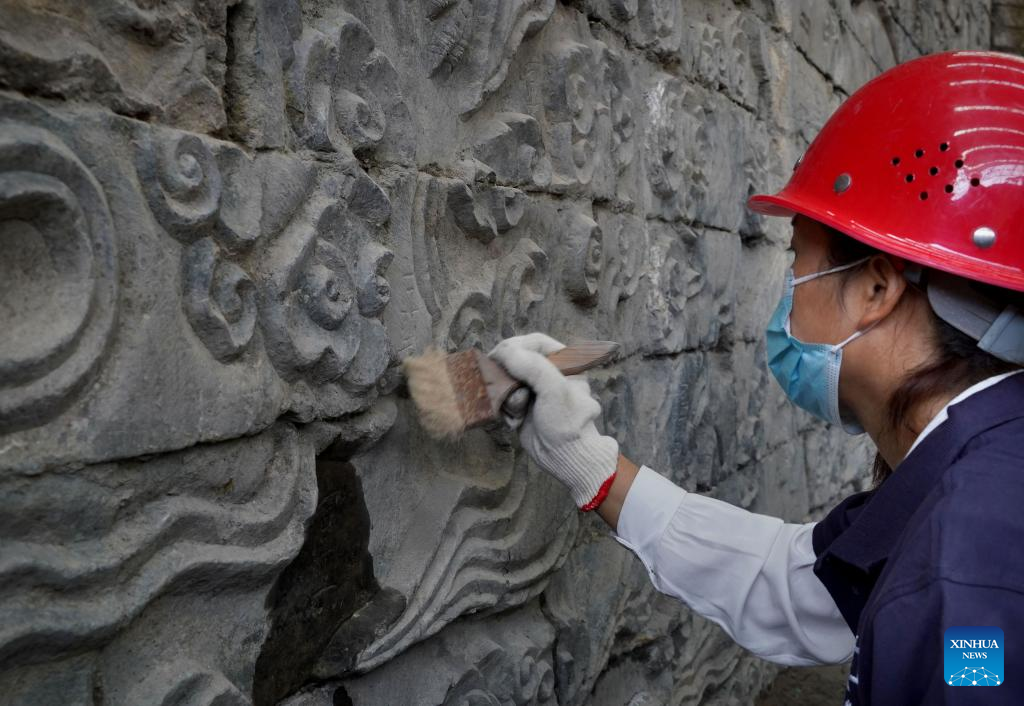 A staff member cleans a stone mural discovered in the Zhouqiao relics site in Kaifeng City, central China's Henan Province.