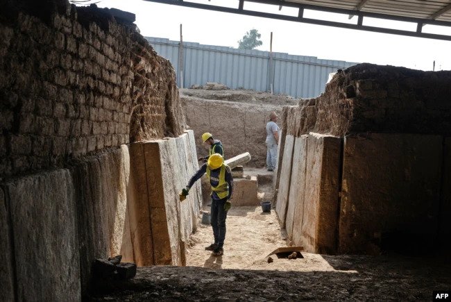 Iraqi workers excavate a rock-carving relief recently found at the Mashki Gate, one of the monumental gates to the ancient Assyrian city of Nineveh, on the outskirts of what is the northern Iraqi city of Mosul.