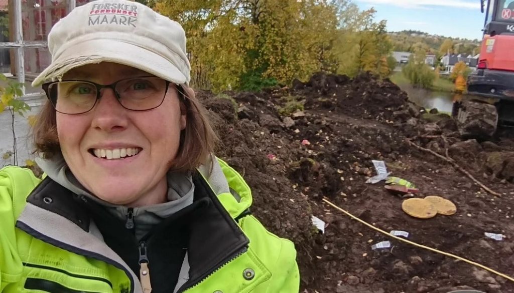 Archaeologist Marianne Bugge Kræmer with the view from the discovery site. Holmendammen can be seen in the background.  Photo: Byantikvaren, Oslo.
Archaeologist Marianne Bugge Kræmer with the view from the discovery site. Holmendammen can be seen in the background.  Photo: Byantikvaren, Oslo.