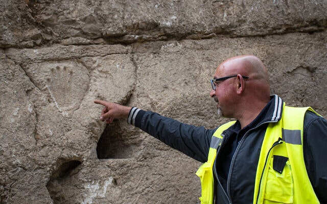 Zubair Adawi, Israel Antiquities Authority excavation director, points to a carved hand imprint discovered in an ancient moat wall around the Old City of Jerusalem. Photo: Yoli Schwartz/Israel Antiquities Authority
