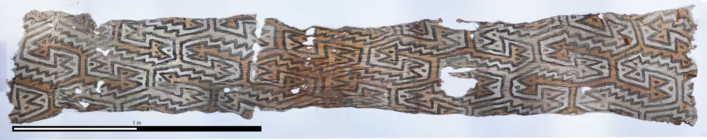 Окрашенная ткань, найденная в гробнице в верхней части участка, датируемая 772–989 гг. Н.э.