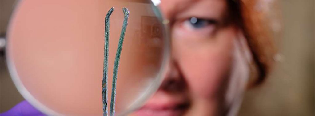 An English Heritage conservator examines a pair of tweezers used to remove armpit hair from Roman men and women. Photograph: Jim Holden/English Heritage