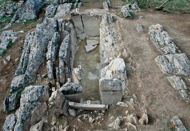 A feltárt Piedras Blancas sír vagy megalitikus sír általános képe keletről, a kövek számozásával.  A túlsó végén a két „nyílszerű” lap az alapkőzethez erősítve.  Fotó: M. Ángel Blanco de la Rubia és L. García Sanjuán / Antiquity Publications Ltd