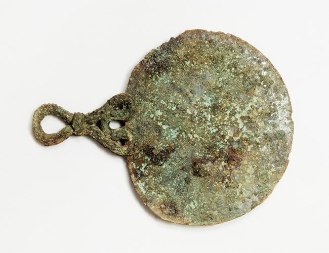 The bronze mirror found in a 2,000-year-old Iron Age burial on Bryher, the Isles of Scilly, just off the coast of Cornwall. Photo: Historic England