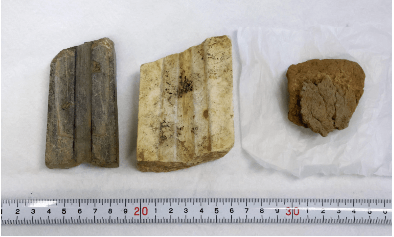 Photo taken on Dec. 4, 2023, shows relics -- stone molds to cast bronze artifacts and a piece of clay vessel (R) -- discovered at the Yoshinogari ruins in Saga Prefecture. (Kyodo)