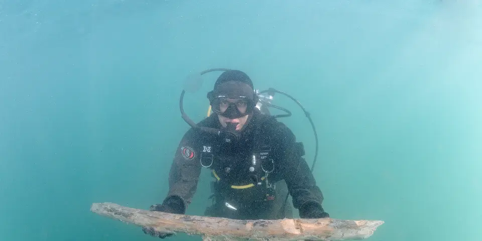 An underwater archaeologist holds a section of an ancient mast found on the seabed near Portorož. Photo: The Institute for Underwater Archaeology
