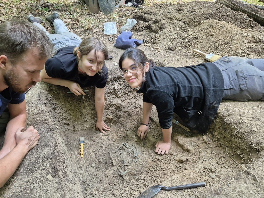 The treasure before being unearthed. Péter Mogyorós PhD student, Nikolett Dienes, and Angéla Farkas archaeology students. Photo: ELTE BTK Régészettudományi Intézet blogja (ELTE BTK Archaeological Institute blog)