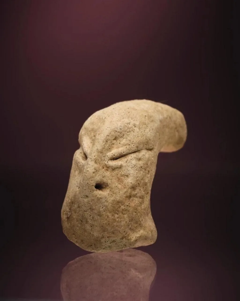 A piece of clay depicting a small human head dating back to 7.700 years ago was unearthed in the Subiya desert. Image Credit: KUNA