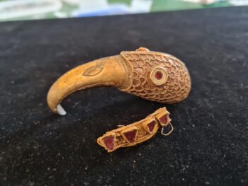 Metal detectorists found these two gold-and-garnet objects in a field in England. Credit: Chris Phillips