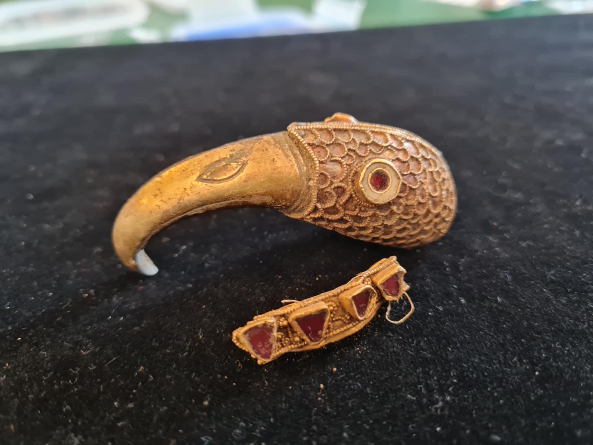 Metal detectorists found these two gold-and-garnet objects in a field in England. Credit: Chris Phillips