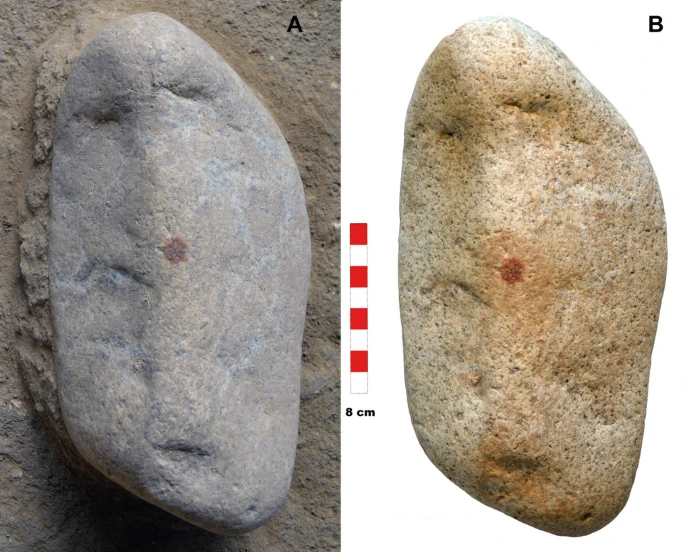 A. The object, still buried, waits quietly beneath layers of time.B. Once unearthed, three cavities and a red dot at the center hint at a purposeful human touch. Credit: Archaeological and Anthropological Sciences (2025). DOI: 10.1007/s12520-025-02243-1