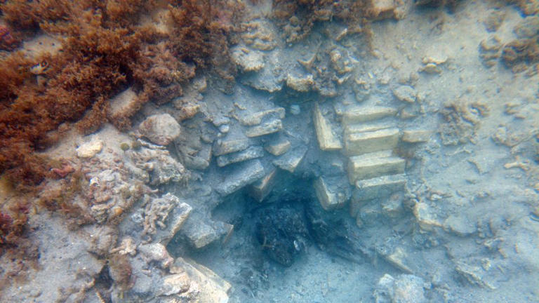 Seen here is an excavated hole with visible bricks and wood from the shipwreck. Credit: John Fhær Engedal Nissen/The National Museum of Denmark