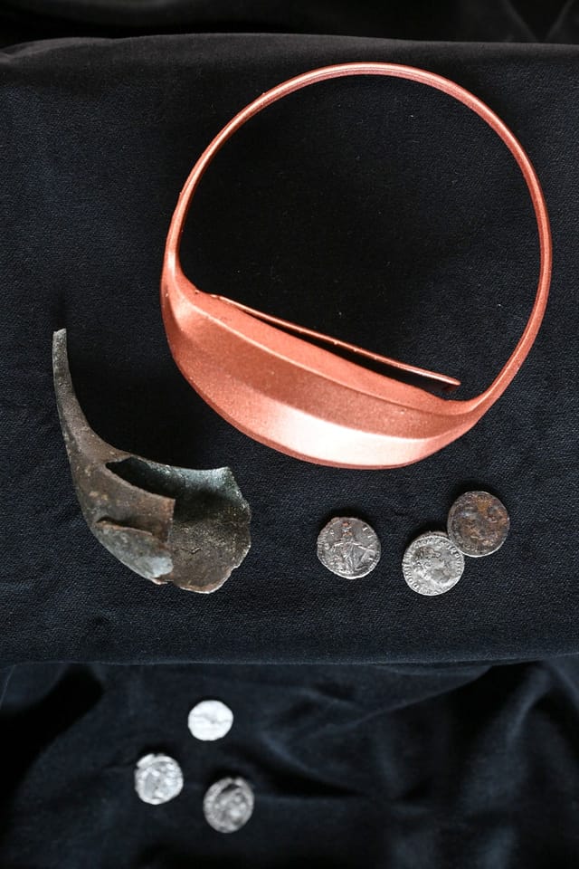 A 1,845-year-old fragment of a Roman wrist purse found at Hradisko u Mušova fortress. The image also shows a replica of the wrist purse at the top and excavated coins at the bottom. Credit: Václav Šálek, ČTK
