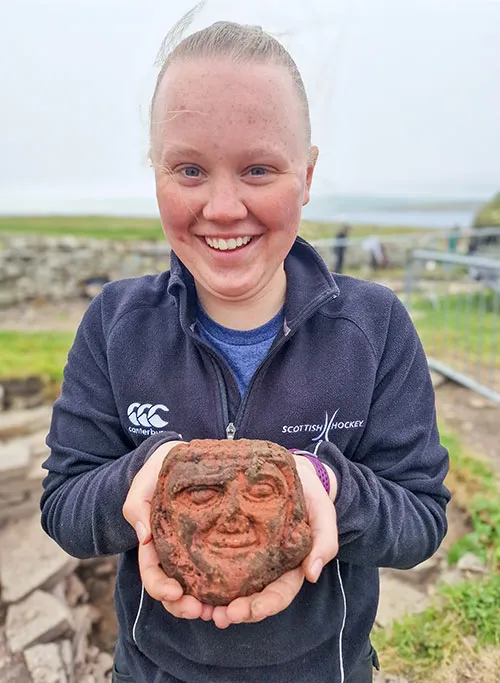 Find of a lifetime – UHI Archaeology Institute undergraduate student Katie Joss with the Skaill carved head. Credit: University of the Highlands and Islands Archaeology Institute – Archaeology Orkney