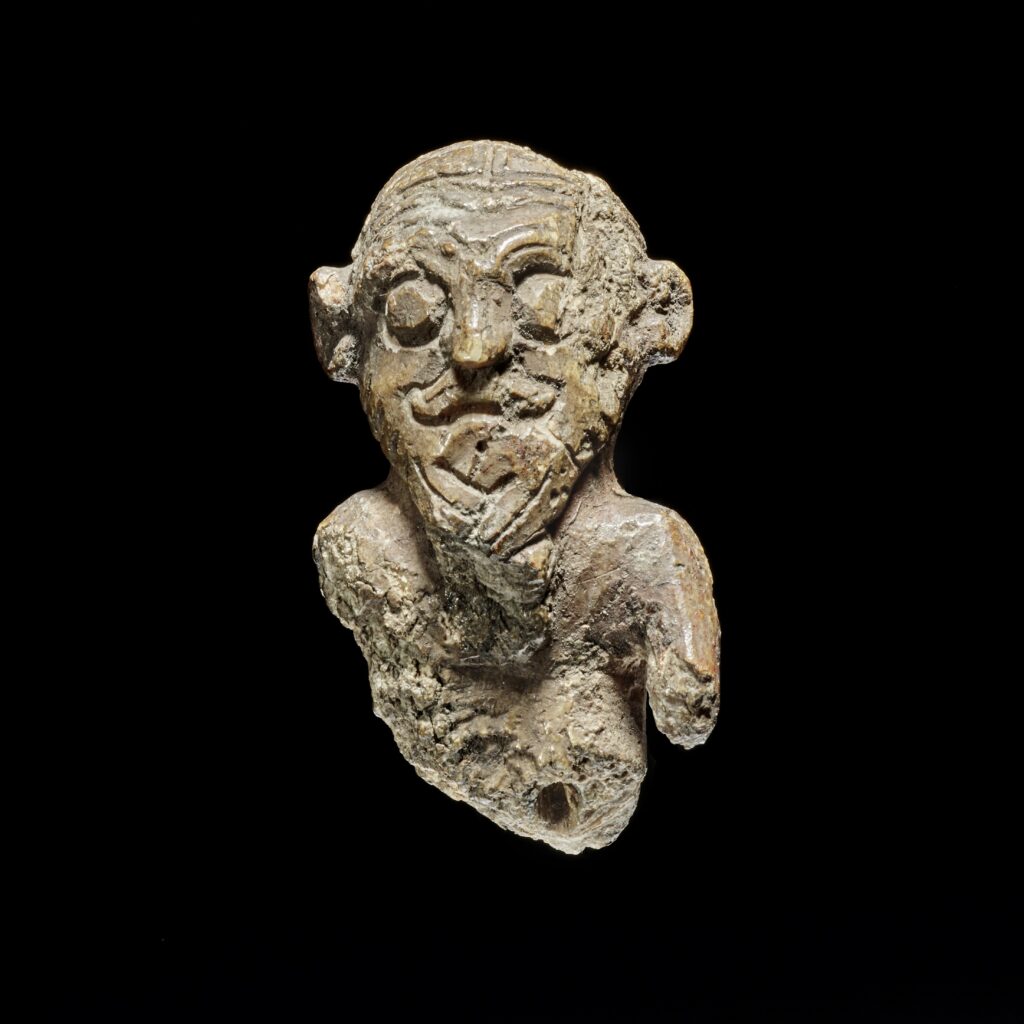 Small, unique gaming piece from the Viking Age, on black background. Credit: Roberto Fortuna, the National Museum of Denmark.