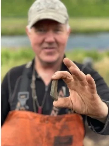 
Patrick Saltonstall holds a stone blade from the oldest level of Alagnaruartuliq site. Credit: Alutiiq Museum 