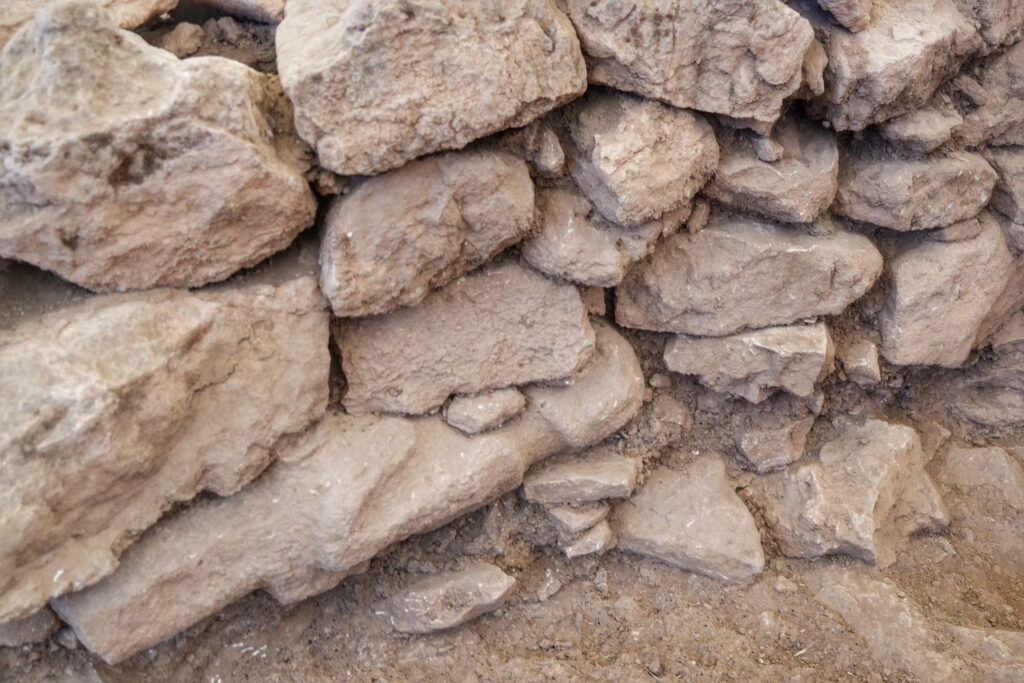 Archaeologists have uncovered a human statue carefully mounted inside a wall, believed to have been placed there as an offering more than 12,000 years ago. Credit: Republic of Türkiye, Ministry of Culture and Tourism