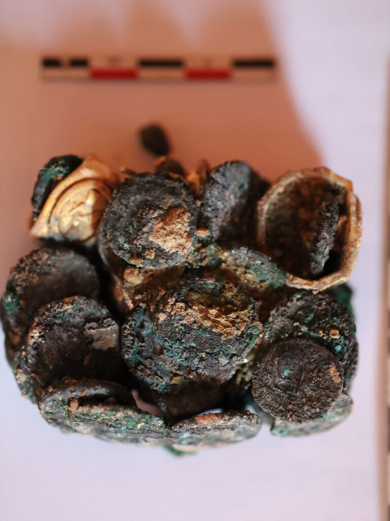 Jewelry and coins, once kept in a wooden chest, fused together by fire in the 2nd–3rd century AD, preserving the chest’s outline. Credit: Muzeul Național de Istorie a României