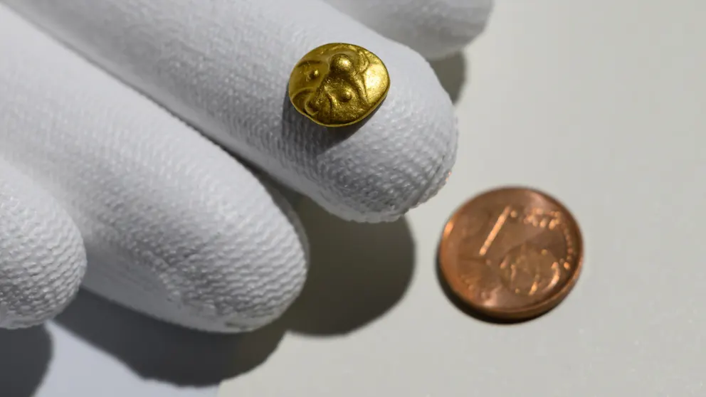 The 2,200-year-old Celtic gold coin — smaller than a one-cent piece — was presented in Dresden. Credit: Robert Michael / dpa.