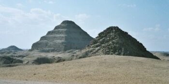 View of Saqqara necropolis, including Djoser's step pyramid (centre), the Pyramid of Unas (left) and the Pyramid of Userkaf (right)