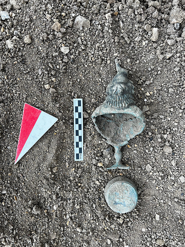 The artifact depicts the goddess Isis standing on a three-legged base that emerges from a three-leaf calyx design. Credit: AA