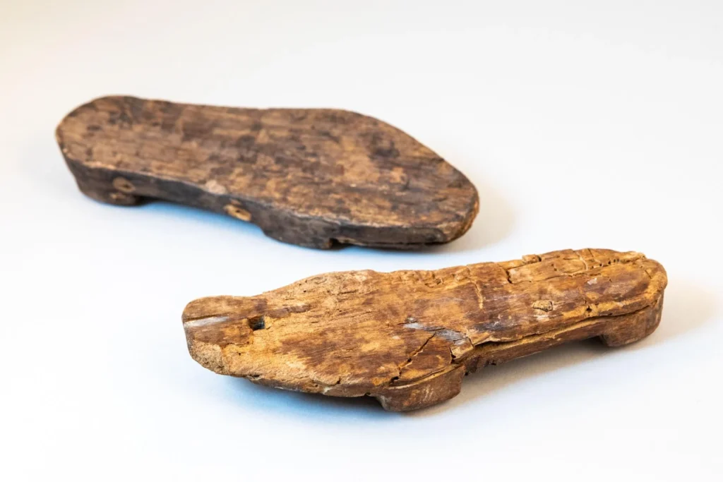 The two maple wooden soles, belonging to sculponae-type shoes (wooden-soled footwear with a leather upper fixed by nails.) Credit: Flore Giraud, Inrap