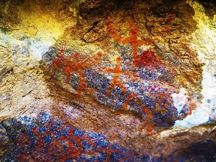 Detail of human-shaped motifs rendered in red pigment on the inner rock face, interpreted as one of the earliest symbolic scenes in Central Anatolia. Credit: IHA