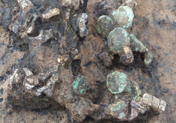 Gold sheets and a coin deposit found mixed with the cremated bone fragments. Credit: Frédéric Prodeo, Inrap