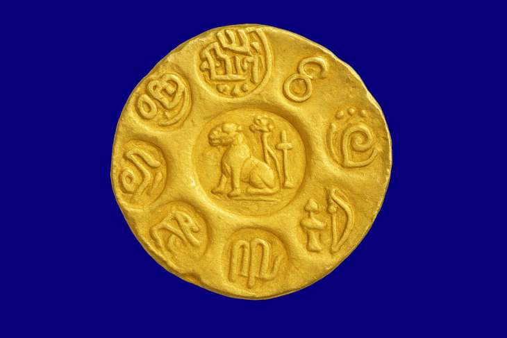 Representative image of a gold coin from the reign of Kulothunga Chola I (1070 – 1120 AD). The coin depicts two fish, a seated tiger, a bow, and two lamp stands at its centre. The punched legend reads “Malai Nadu Konda Chola,” and the regnal year inscribed is 36. It commemorates Kulothunga’s conquest of Malainad, most likely the Malabar coast. Credit: Chennai Museum.