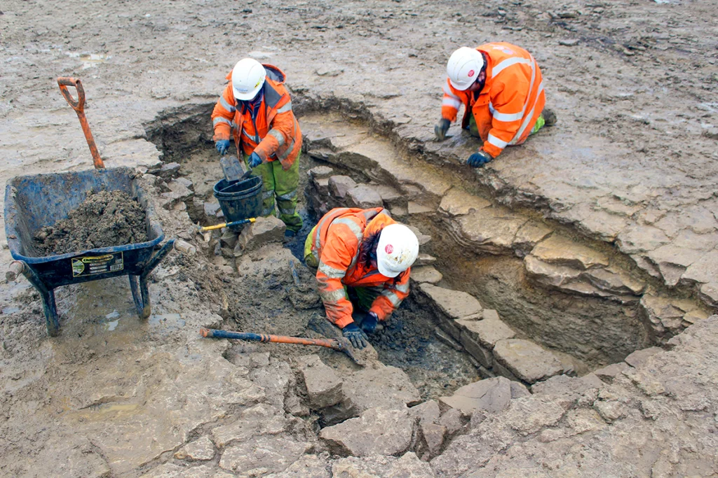 OCA archaeologists excavating a Roman corn dryer. Credit: Oxford Cotswold Archaeology