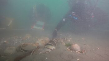 Divers from the National Research Institute of Maritime Cultural Heritage inspect a tightly stacked bundle of celadon bowls on the seabed off Taean, a West Sea coast renowned for its expansive tidal mudflats and historic maritime corridors. Credit: Yonhap News Agency.