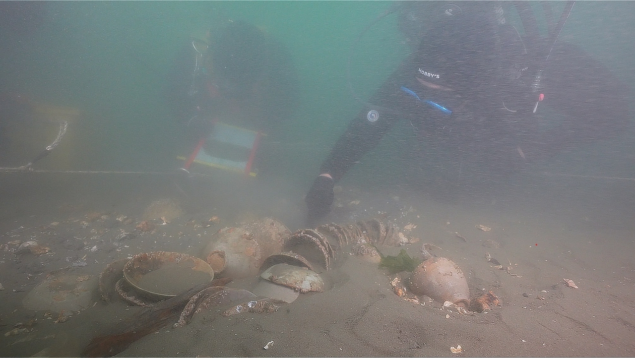 Divers from the National Research Institute of Maritime Cultural Heritage inspect a tightly stacked bundle of celadon bowls on the seabed off Taean, a West Sea coast renowned for its expansive tidal mudflats and historic maritime corridors. Credit: Yonhap News Agency.