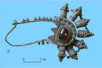 Silver fibula pendant set with a garnet, discovered in an elite early medieval child burial from the Upper Ob region of Siberia. Credit: Novosibirsk State Pedagogical University (NSPU)