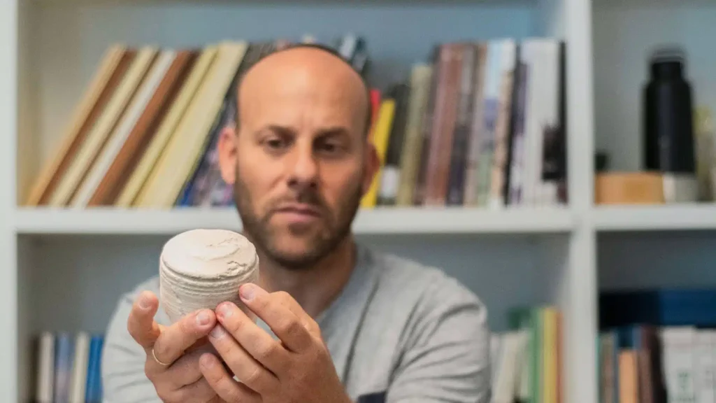 Archaeologist Eitan Klein holds a limestone vessel recovered from the Second Temple period workshop discovered on Mount Scopus in Jerusalem. Credit: Israel Antiquities Authority via Facebook