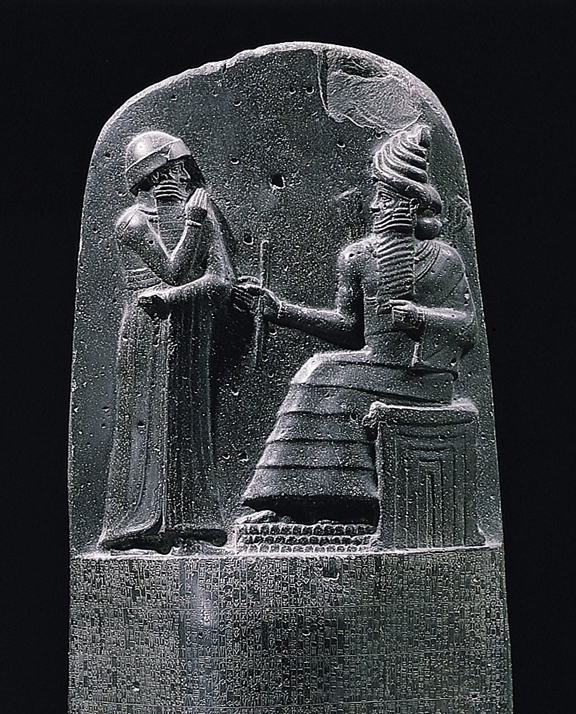 Upper section of the stele depicting Hammurabi’s Stele: a seated king, representing Hammurabi, is shown in conversation with a figure standing before him—likely an attendant or divine intermediary—who wears a helmet-like headdress. Credit: Public Domain