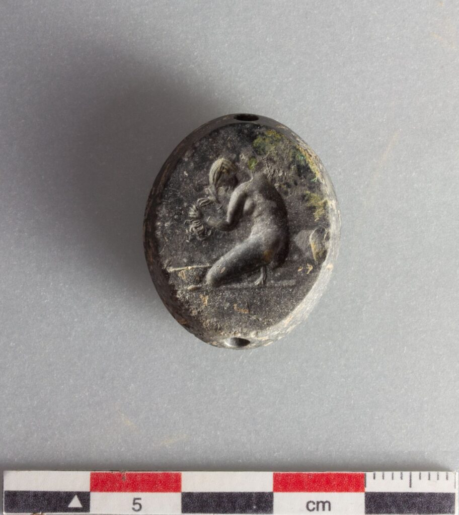Seal stone depicting a kneeling woman bathing. Credit: Greek Ministry of Culture