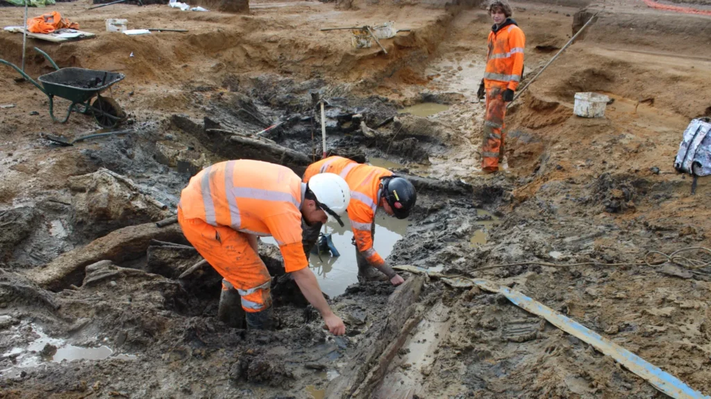 Archaeologists digging deeper into the well and discovering layered platforms. Credit: Cotswold Archaeology 