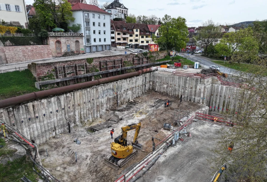 Excavation pit with the discovery. The remains of the Iron Age structure are visible in front of the pile wall. Credit:  Bayerisches Landesamt für Denkmalpflege (BLfD)