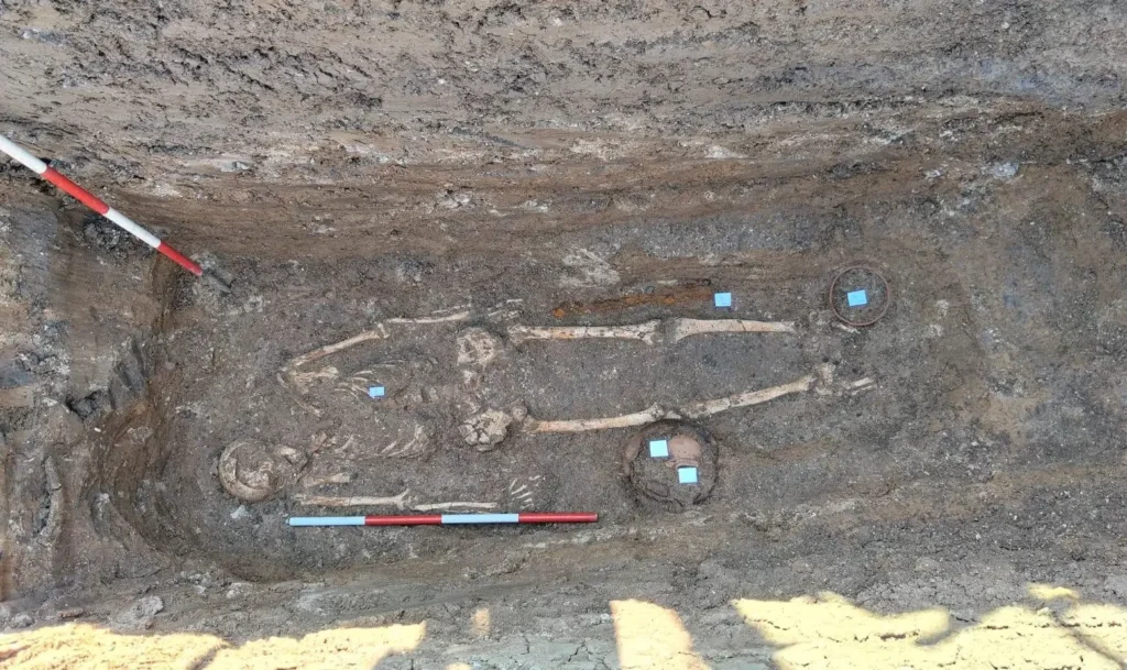Simple pit grave containing grave goods, including an iron ornament and several ceramic vessels. Credit: Ministero della Cultura (MiC)