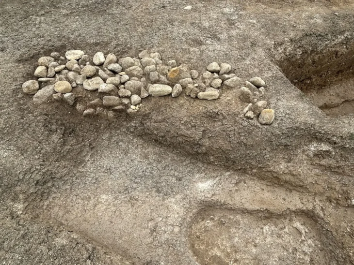 Stone-filled burial pits dating to the 5th–4th centuries BC, along with the visible stone covering of a grave, at the pre-Roman necropolis in Vasto. The pits show different depositional levels and overlapping relationships, as seen in the cuts of other burials visible in the image. Credit: Ministero della Cultura (MiC)