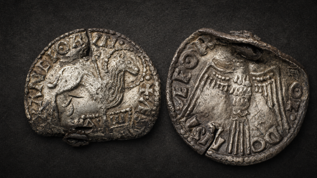 Anverso y reverso de la rara moneda anglosajona Agnus Dei: el anverso muestra al Cordero de Dios traspasado por una cruz y de pie sobre el Alfa y la Omega, mientras que el reverso presenta la paloma del Espíritu Santo, reflejando el fuerte simbolismo cristiano de la moneda. Crédito: Søren Greve y John Engedahl Nissen. Museo Nacional de Dinamarca